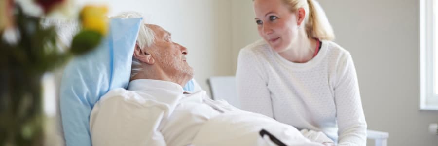 Resident in hospice care being comforted by a caretaker at Montello Care Center in Montello, Wisconsin