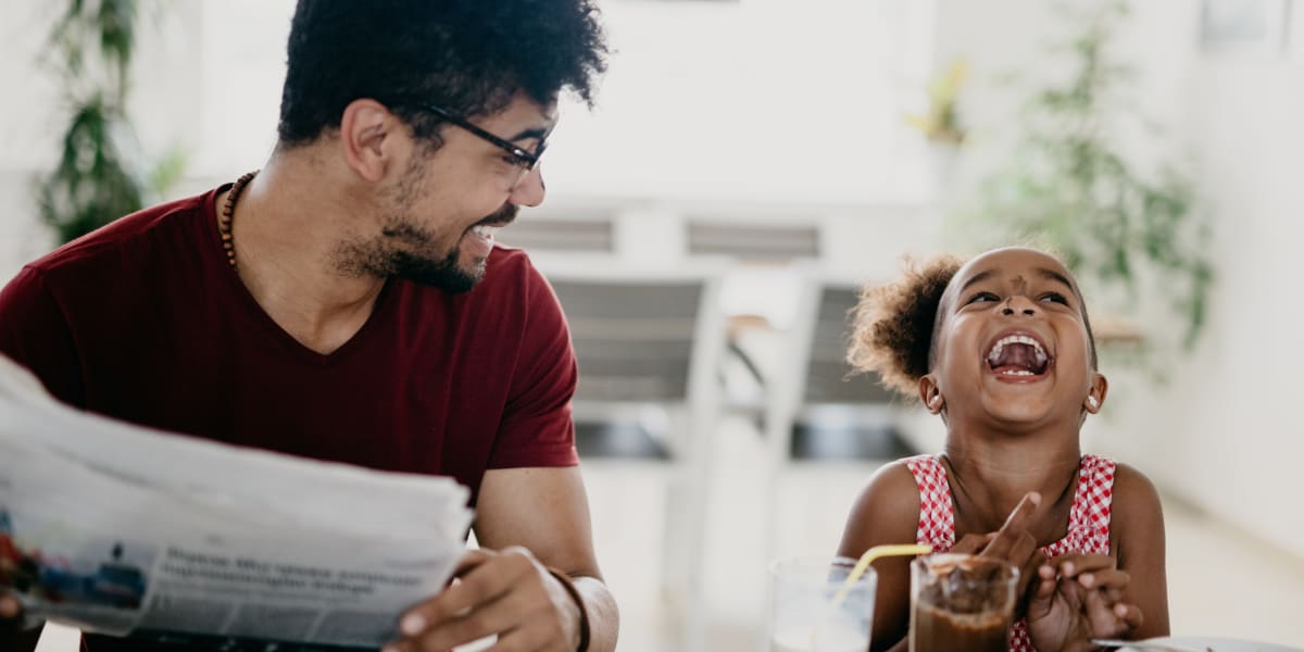 Resident laughing with daughter at breakfast table at Marquis at Sonoran Preserve in Phoenix, Arizona