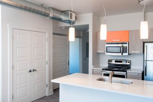 Retro-modern furniture and classic decor in a model home's living area at Midtown Lansing Apartments in Lansing, Michigan