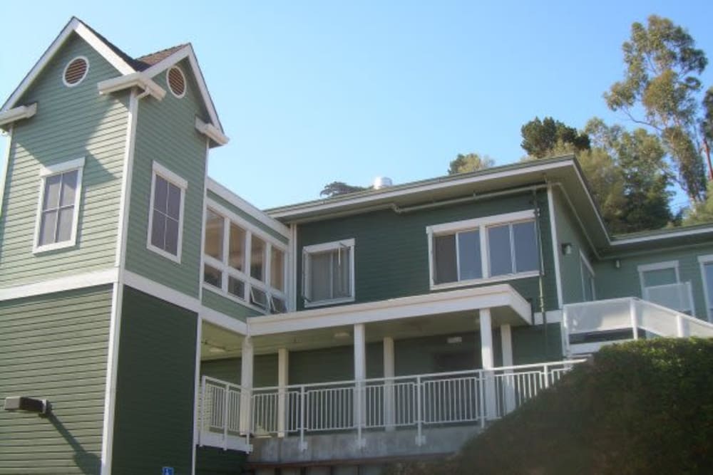 The main building with green tones of paint and white highlights in Vista Terrace of Belmont in Belmont, California
