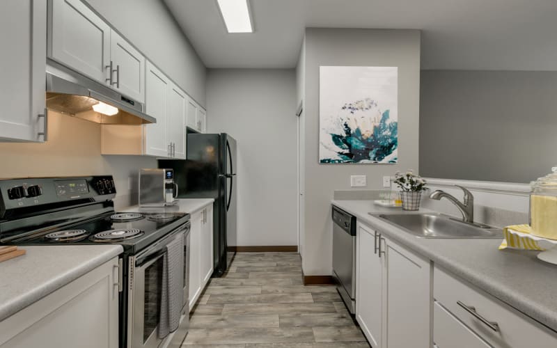 Recently renovated kitchen with white cabinets and stainless steel appliances at The Landings at Morrison Apartments in Gresham, Oregon