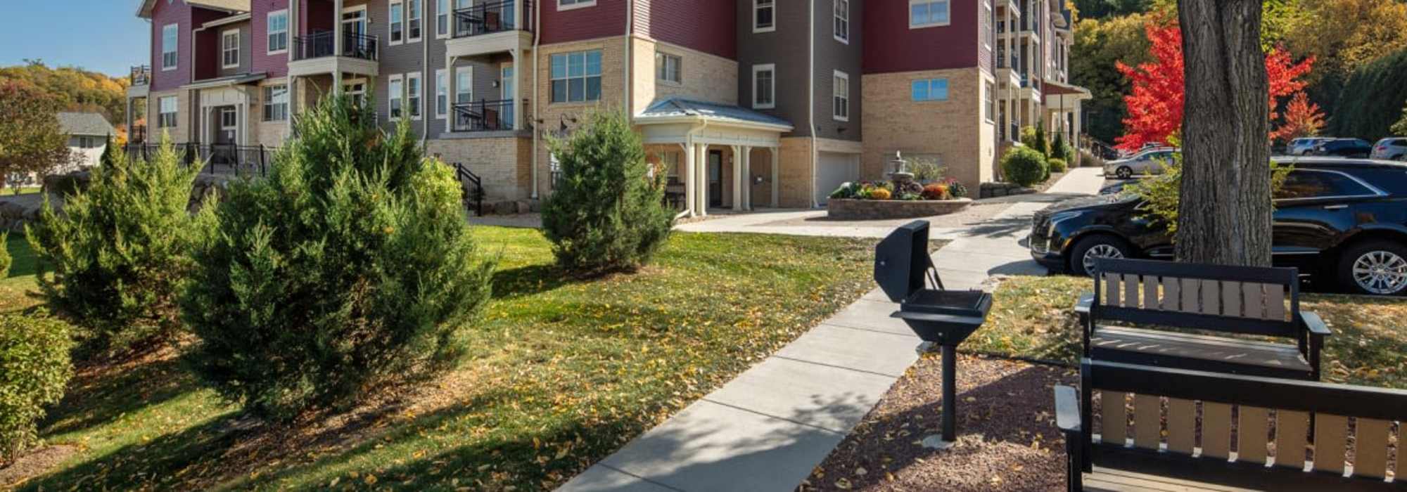 EXterior shot with courtyard, grilling area and off street parking at Mill Creek Apartments in Cross Plains, Wisconsin