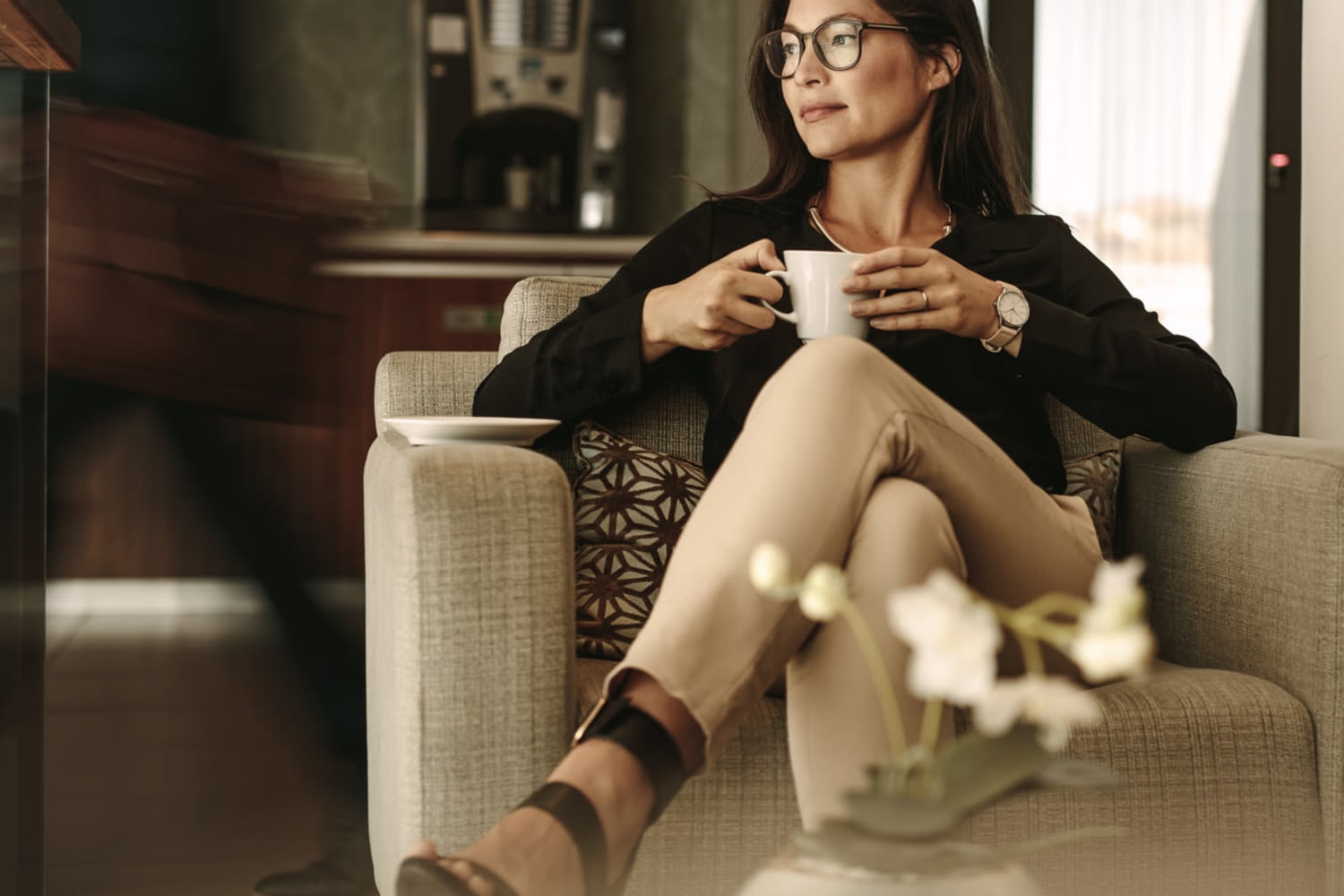 Woman relaxing on the couch with a cup of coffee at The Parker Fulton Market in Chicago, Illinois