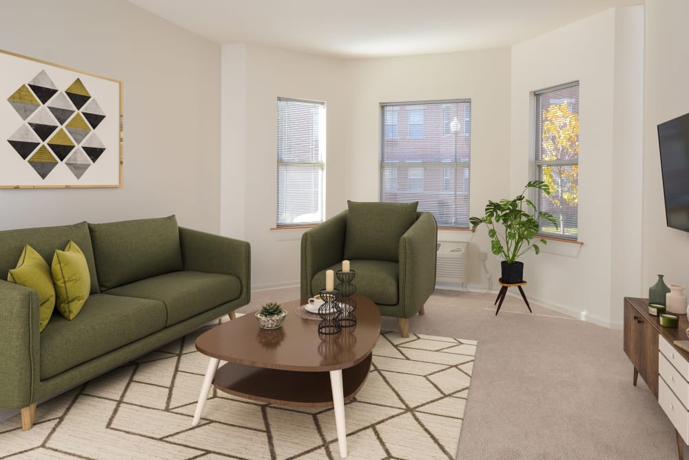 Carpeted living room with bay windows at The Brunswick in New Brunswick, New Jersey