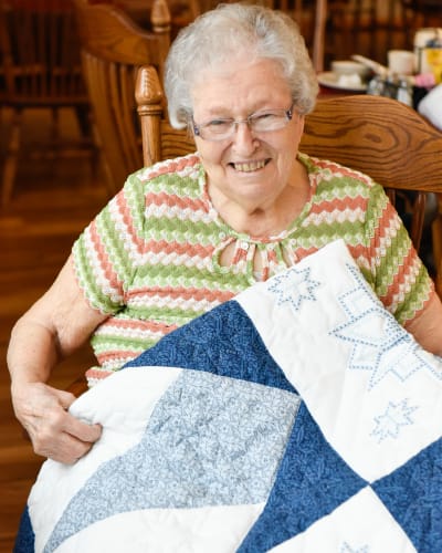 Resident showing the quilt she made at Garden Place Red Bud in Red Bud, Illinois.