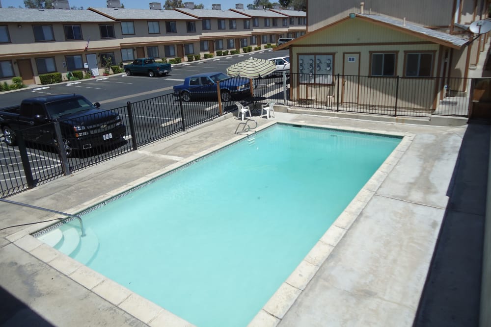 Swimming pool area on a beautiful day at Olympus Court Apartments in Bakersfield, California