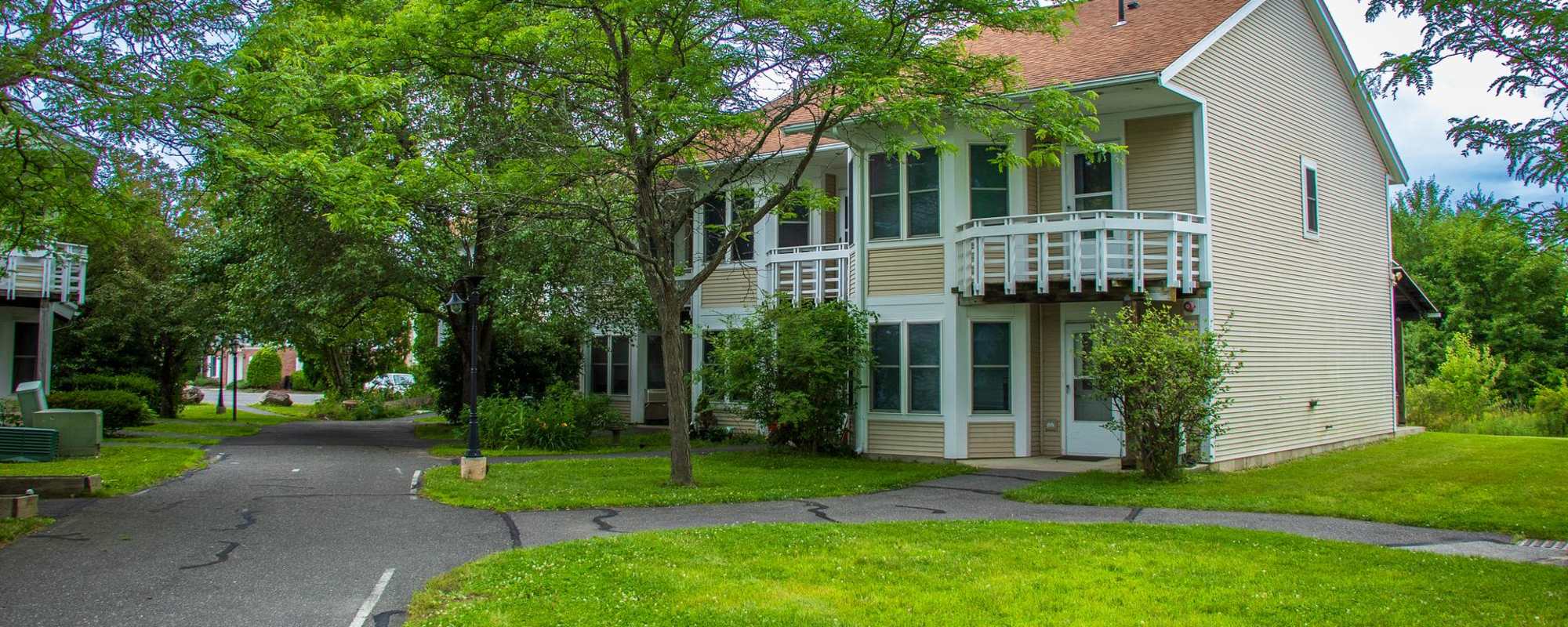 Exterior view of the apartment showing a road and lawn at Pomeroy Lane Cooperative in Amherst, Massachusetts