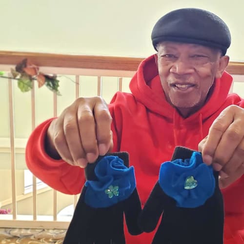 A resident holding up a pair of gloves at Canoe Brook Assisted Living & Memory Care in Catoosa, Oklahoma