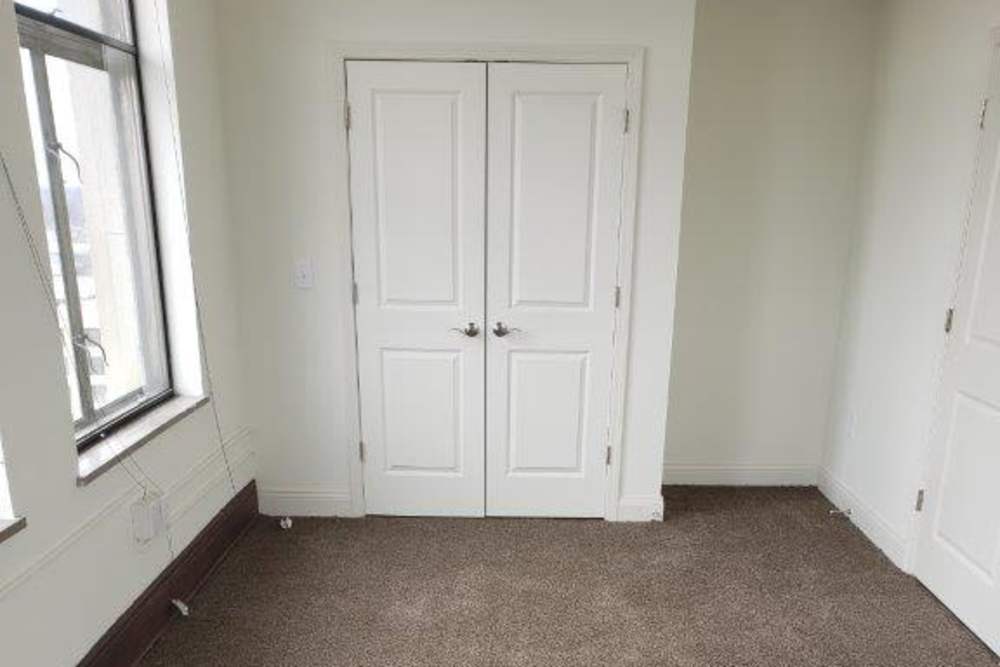 Empty room with two doors and large window letting in natural light at 43 Town Square in Lima, Ohio