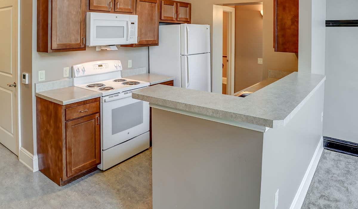 Kitchen with white granite countertops and appliances at Washington School Apartments in Washington Court House, Ohio