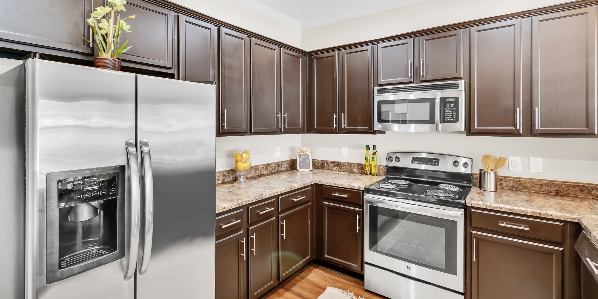 A beautiful kitchen with wood cabinetry in a model home at The Atrium in Daphne, Alabama