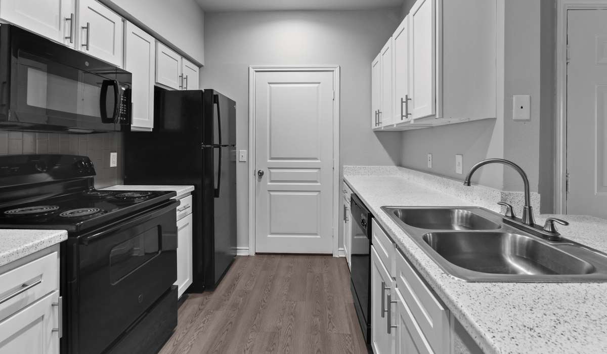Modern kitchen with hard wood flooring at Stoneleigh Corpus Christi in Corpus Christi, Texas