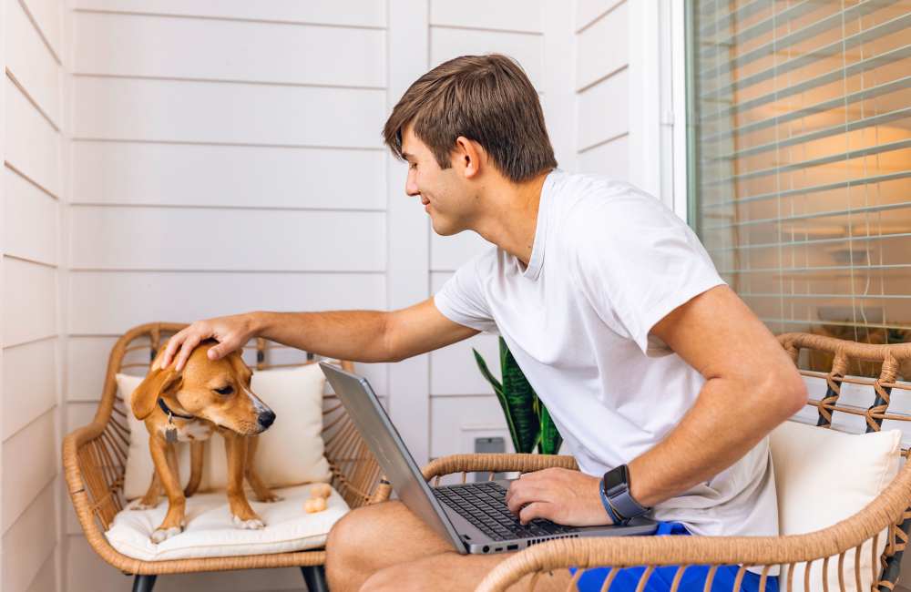 Resident in a living room with his dog at The Waters at Promenade in Marrero, Louisiana