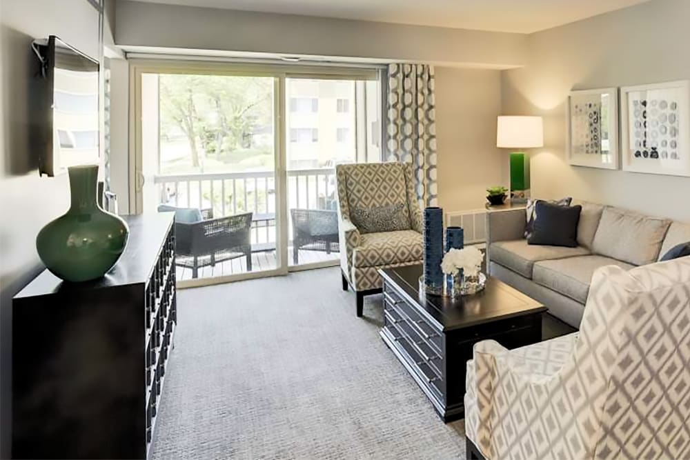 Beautiful model living room with private balcony at Satyr Hill Apartments in Parkville, Maryland