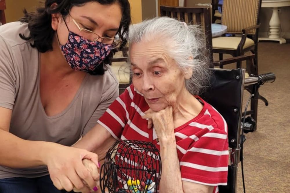 Resident partaking in arts and crafts course with care giver at Woodland Palms Memory Care in Tucson, Arizona