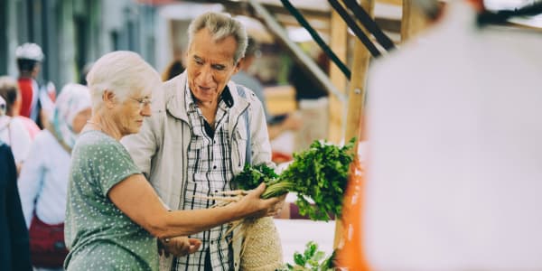 Resident couple out shopping for produce at Bell Tower Residence Assisted Living in Merrill, Wisconsin