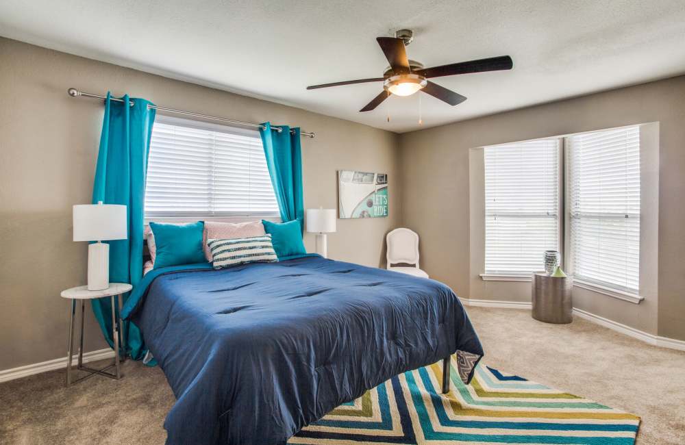 Bedroom with carpet flooring, side lamp, chair and window at Ascent at Lake Worth in Fort Worth, Texas