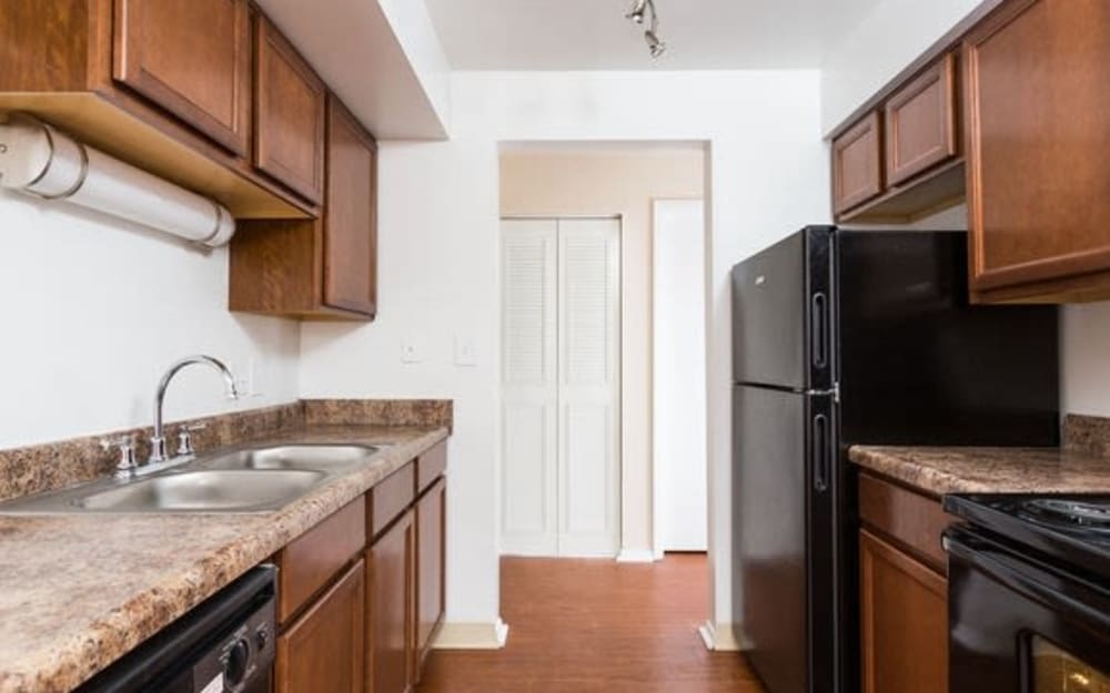 Fully equipped kitchen with black appliances and double stainless steel sinks at Parkside at Castleton Square in Indianapolis, Indiana