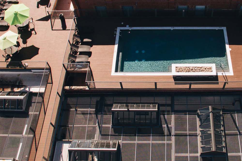 Resort-style pool with lounge chairs at Courtyard Lofts at Scott’s Addition in Richmond, Virginia