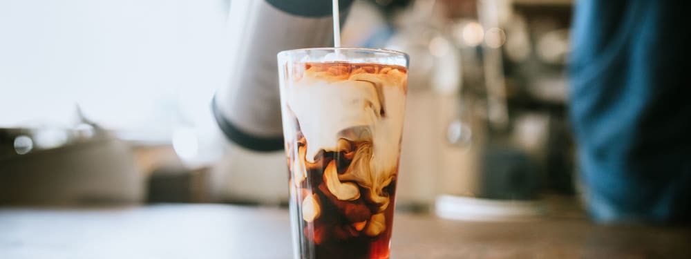A barista pours cream into a glass pint of cold-brew coffee in Salt Lake City, UT