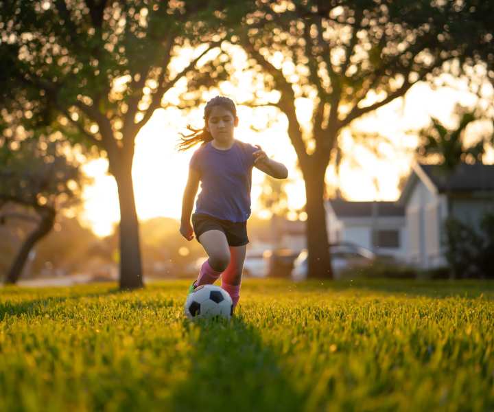 Resident child playing soccer at a park near Addison Grove in Avon Park, Florida