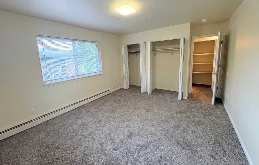 Unfurnished bedroom with a walk-in closet and window at Edgewood Group Apartments in Merrillville, Indiana
