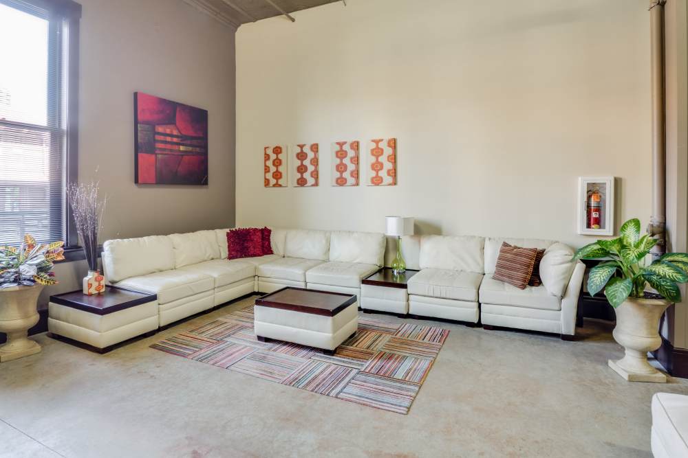 White sectional sofa with colorful artwork at Rumely Lofts in Des Moines, Iowa