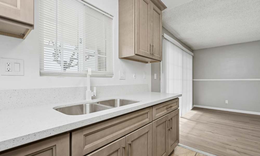 Fully equipped kitchen with window at Newland Garden Apartments in Garden Grove, California