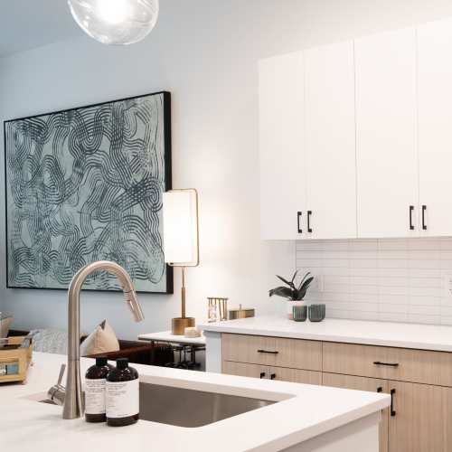 Quartz counters and a tile backsplash in an apartment kitchen at Terrazzo in Durham, North Carolina