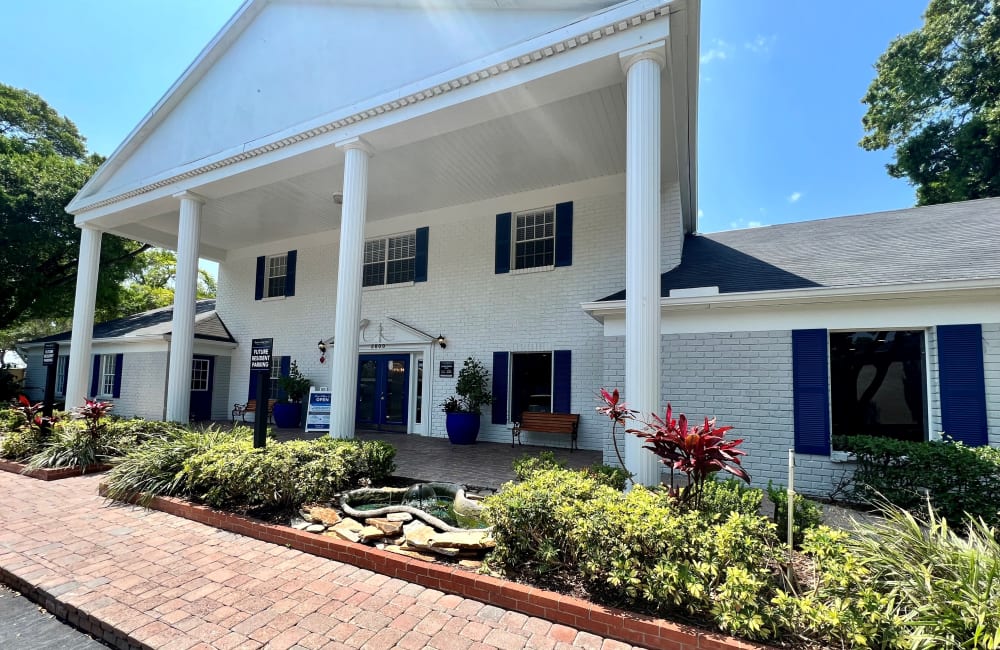 Exterior of the clubhouse with white columns and lush landscaping at Reserve at Lake Pointe Apartments & Townhomes in St Petersburg, Florida