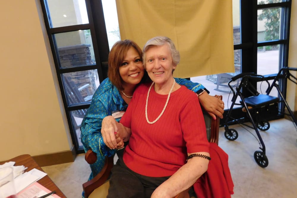 senior woman and staff member smiling at Merrill Gardens at Solivita Marketplace in Kissimmee, Florida. 