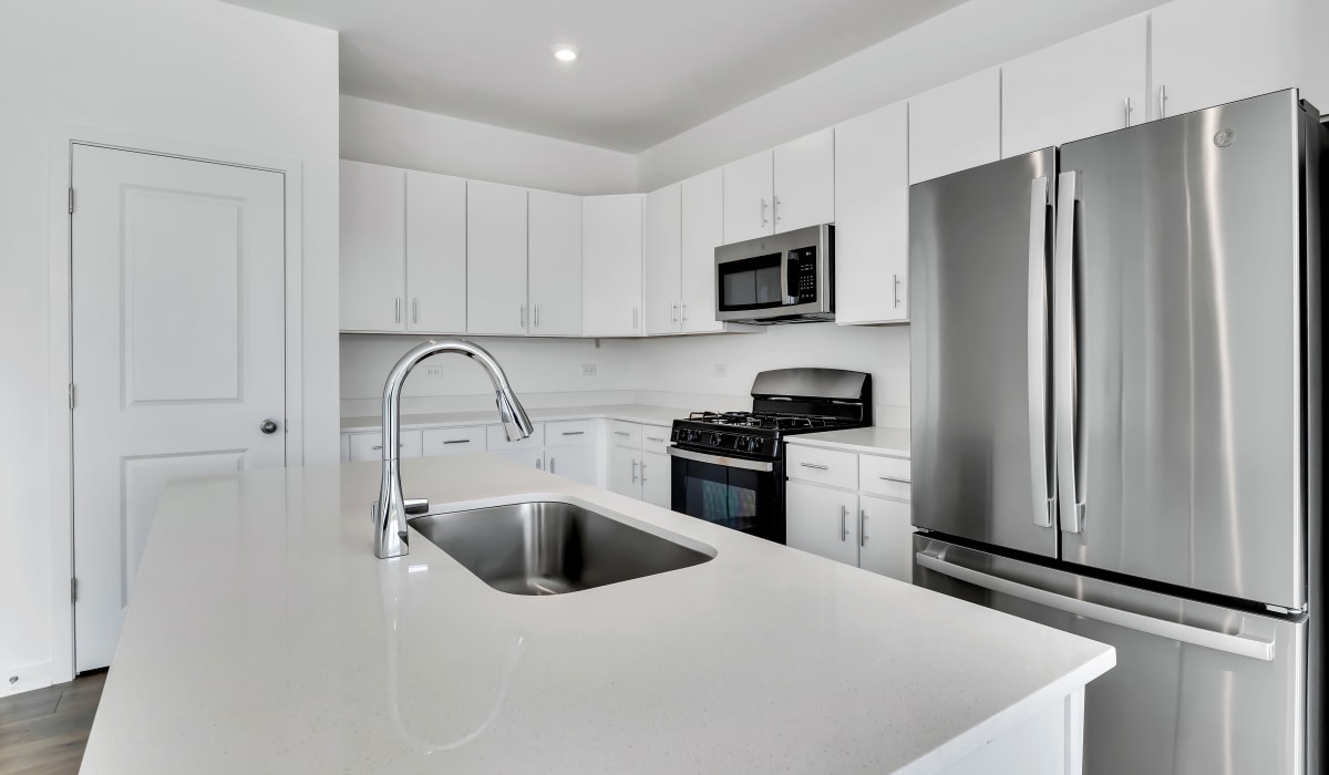 Stainless-steel appliances in a kitchen with a large island at Home at Ashcroft in Oswego, Illinois