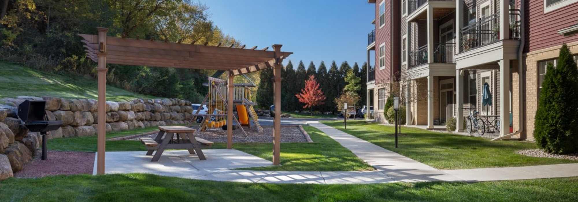 Grilling area and the playground at Mill Creek Apartments in Cross Plains, Wisconsin