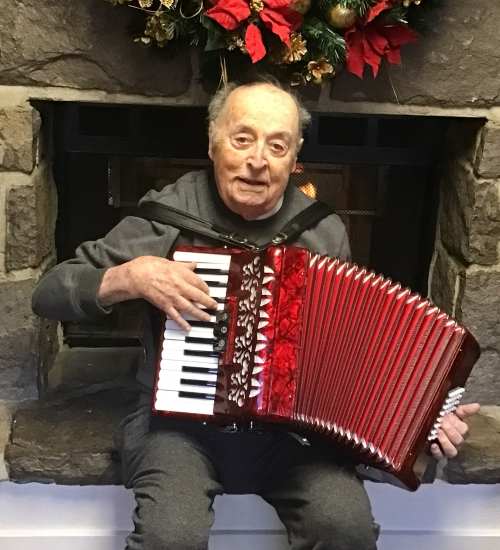 Resident playing an accordion at Truewood by Merrill, Fig Garden in Fresno, California