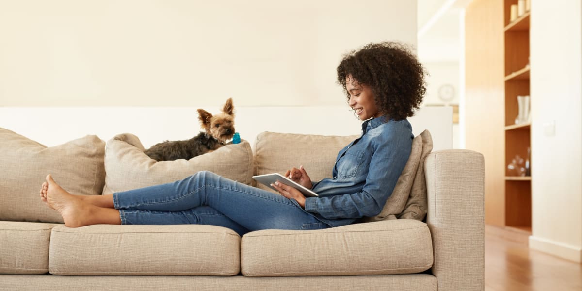 Resident on couch with dog at Legends Grove in Ann Arbor, Michigan