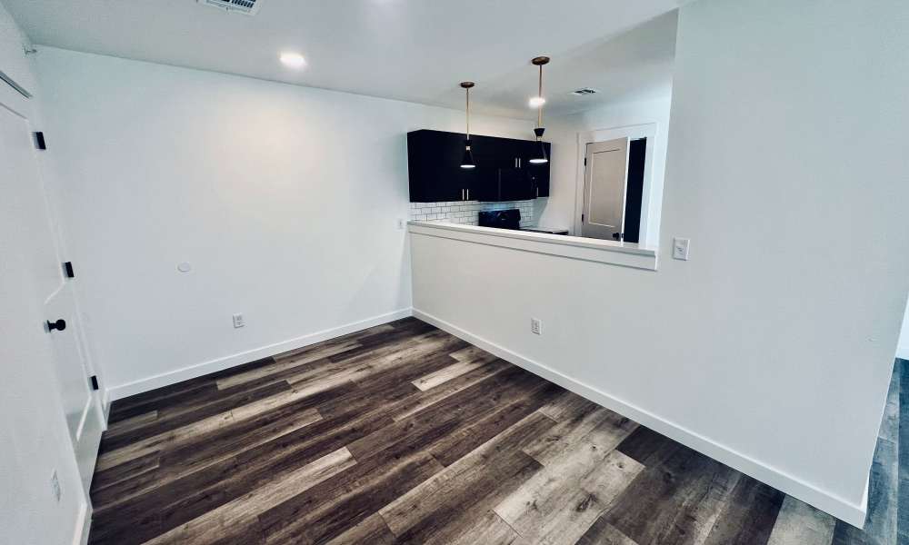 Living and dining space with wooden flooring at Quail Run in Oklahoma City, Oklahoma