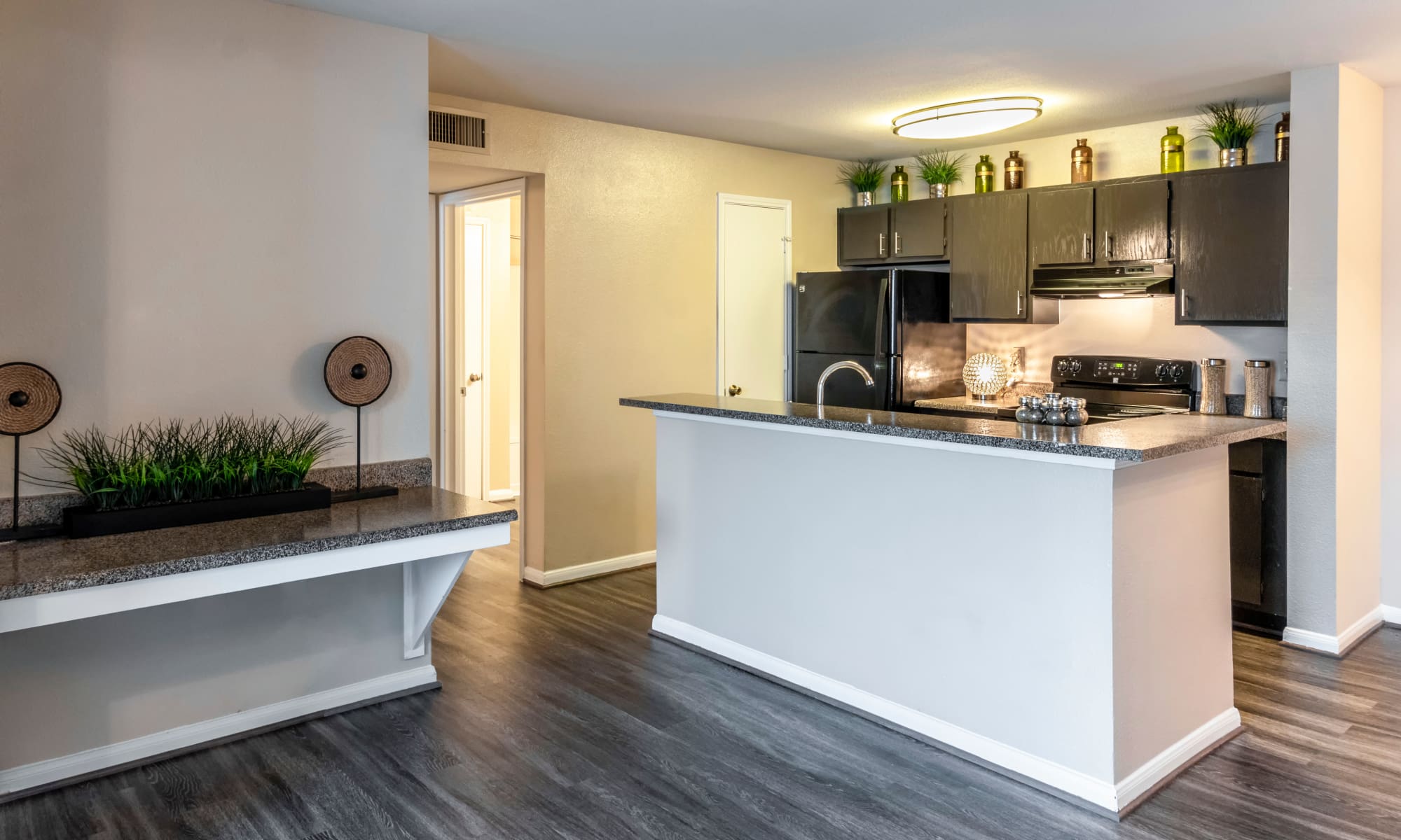 Beautiful hardwood flooring and modern kitchen at Kenwood Club at the Park in Katy, TX