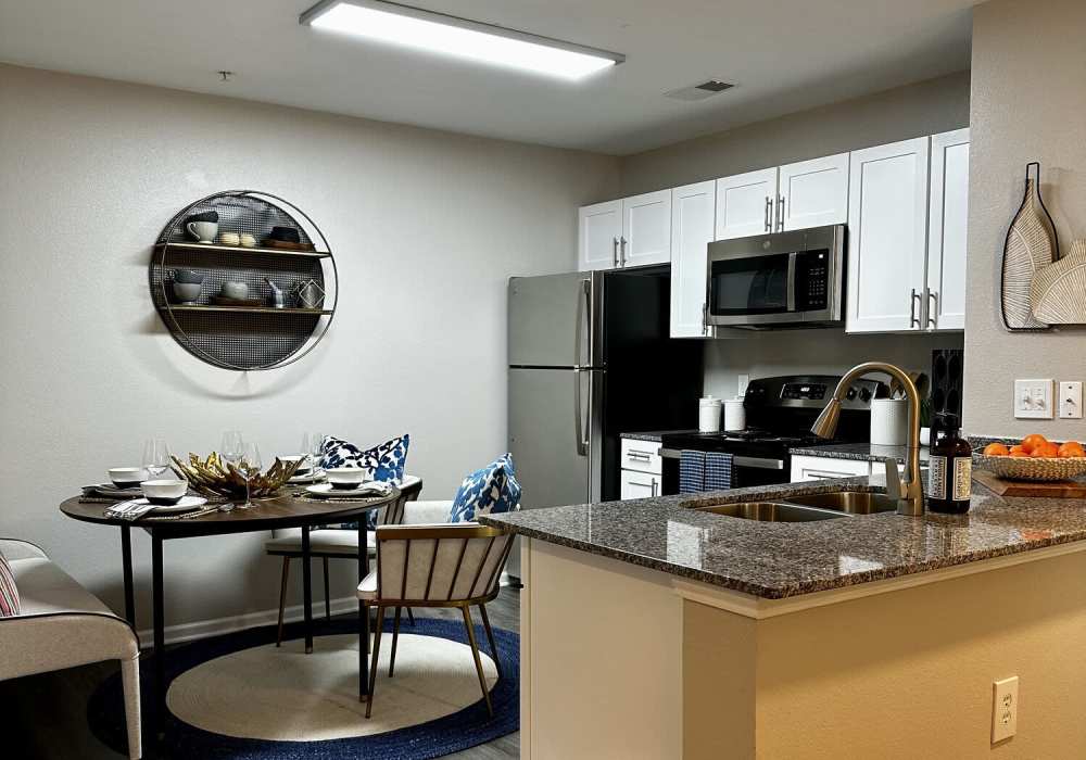 Dining room and kitchen with stainless steel oven and drawer microwave plus granite countertops at Battleground North in Greensboro, North Carolina