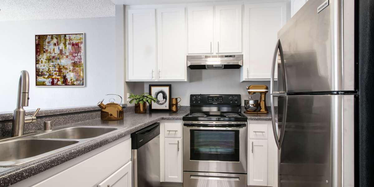 Spacious kitchen with white cabinets and stainless steel appliances at Lakeview Village Apartments in Spring Valley, California