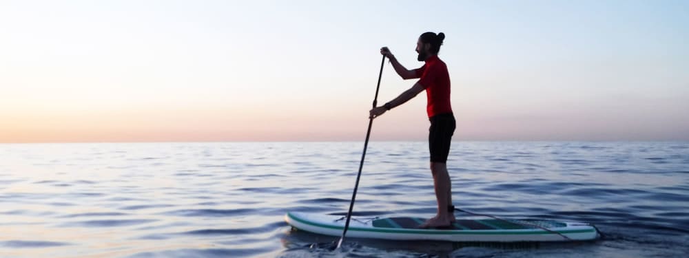 A lone paddleboarder enjoying the serenity near Harborside Marina Bay Apartments in Marina del Rey, California