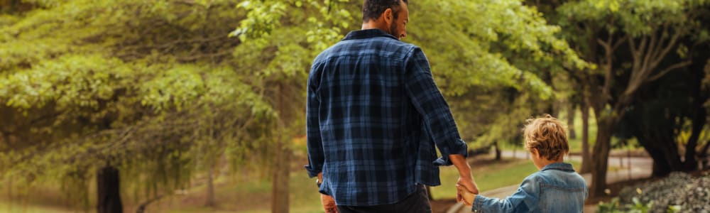 A father walking through a park with his son near Stanton View Apartments in Atlanta, Georgia