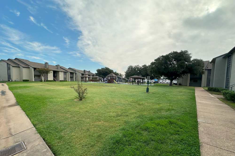 Exterior view of apartments with beautifully landscaped courtyard at Courts of Bedford in Bedford, Texas