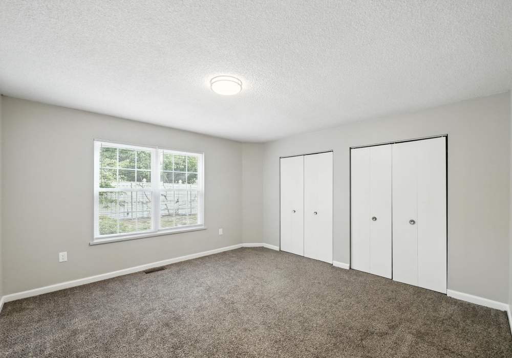 Unfurnished bedroom with carpet flooring and spacious closet at North River Landing in Elkhart, Indiana