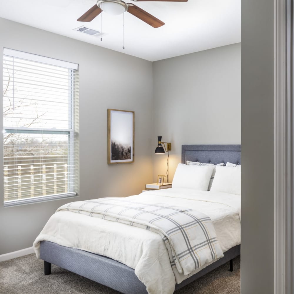 Bedroom with plush carpeting and ceiling fans at Springhill Apartments in Overland Park, Kansas