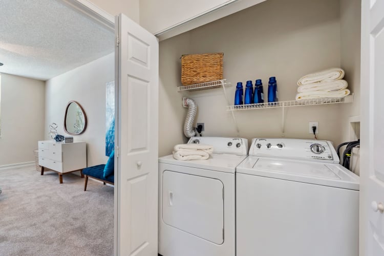 Private washer and dryer with laundry room shelving at Fountain House Apartments in Miami Lakes, Florida