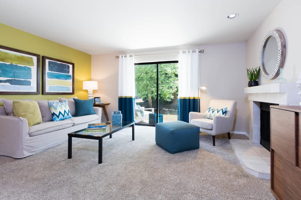 Beautifully decorated living space with plush carpeting in the open-concept floor plan of a model home at Madison Sammamish Apartments in Sammamish, Washington