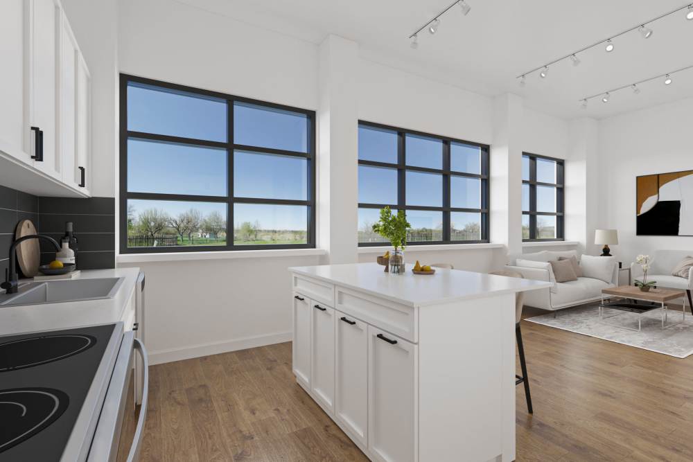 Kitchen with white cabinets, large windows and hardwood flooring at The Franklin in Ankeny, Iowa