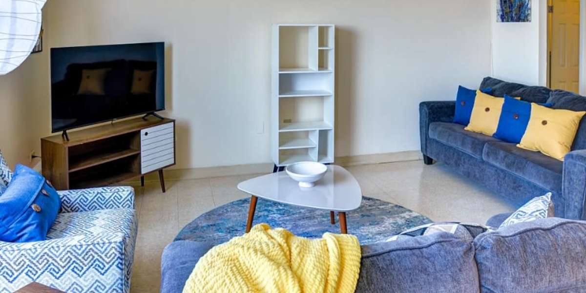 Living room with blue and yellow accent pillows and blankets  at Capitol Green Apartments in Albany, New York
