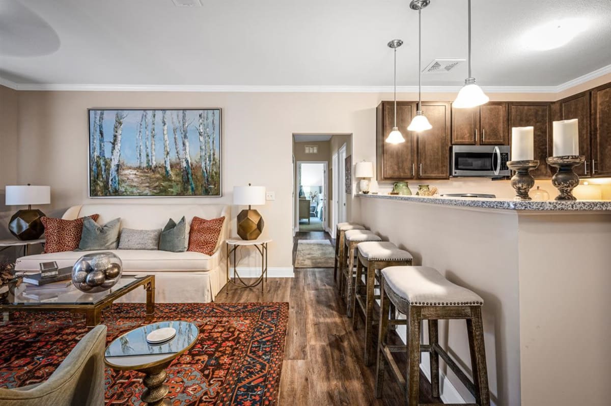 An apartment living room and kitchen leading to the hallway at Bowman Station in Macon, Georgia