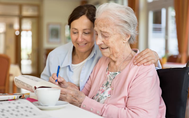 Caretaker doing a crossword with a resident at a The Blake community